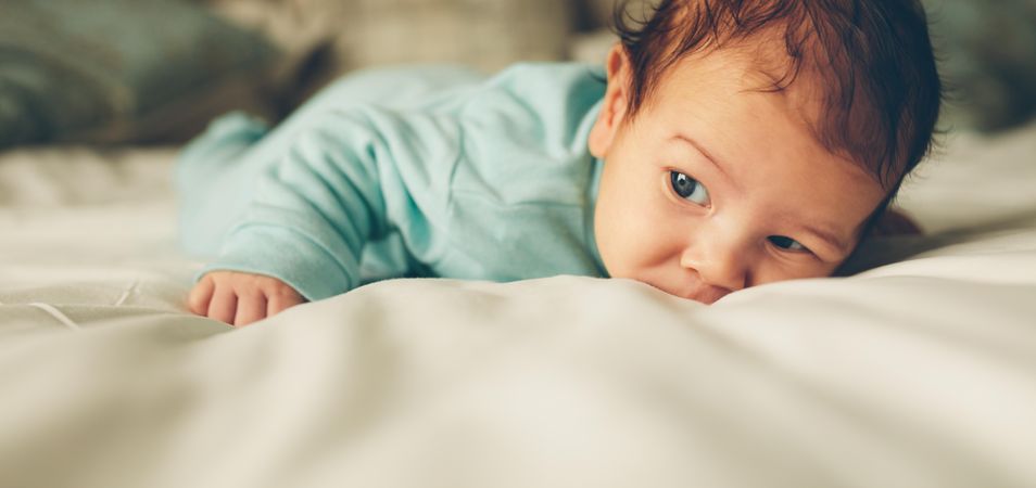 Cute newborn baby lying in bed