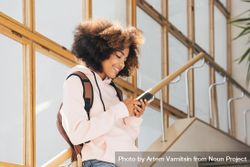 Teenage female student standing on stairs in school while texting 4ADgN5