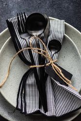 Top view of table setting with dark cutlery & string on concrete background