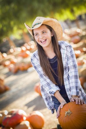 Preteen Girl Playing with a Wheelbarrow at the Pumpkin Patch.