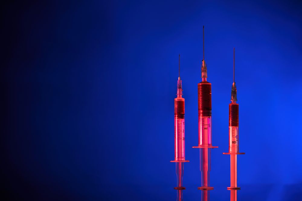 Syringes organized in row on blue background