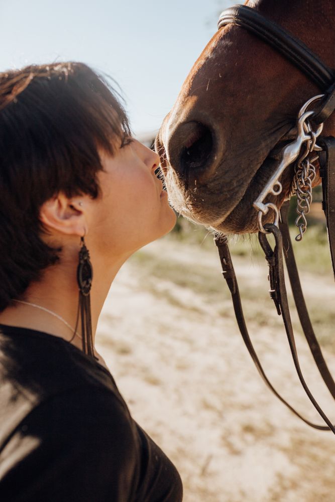Woman kissing horse on ranch
