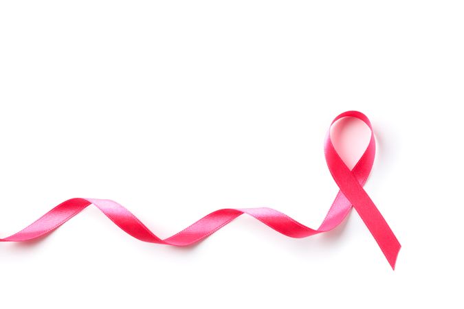 Pink awareness ribbon isolated on blank background, top view