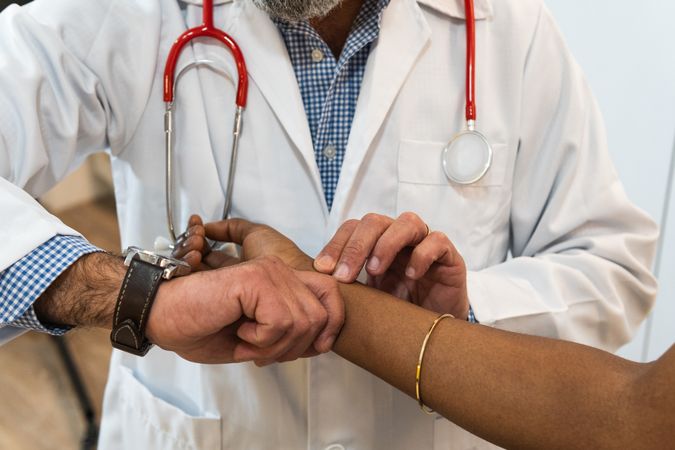 Crop doctor measuring pulse of patient