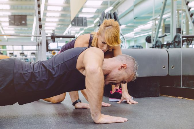 Man doing push ups with female trainer