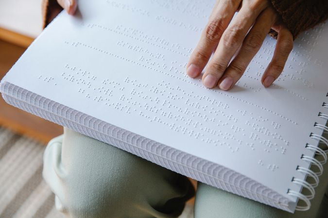 Cropped image of person reading using braille system