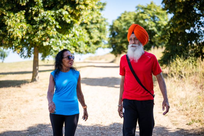 Mature Sikh couple walking in park