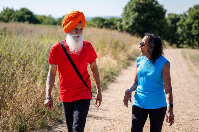 Mature Sikh couple walking in field
