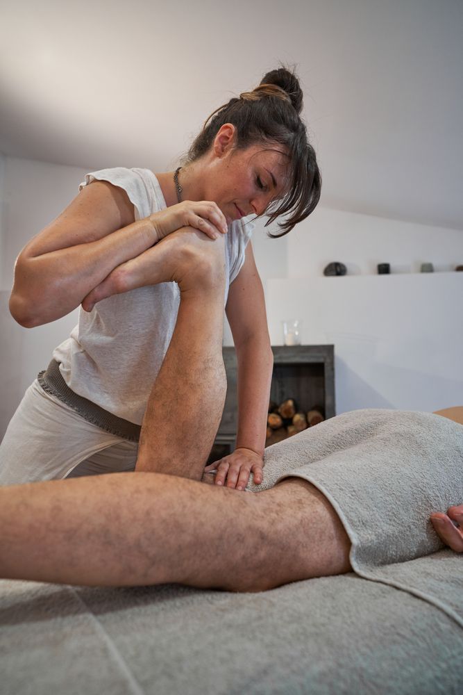 Woman kneading leg of man during massage session