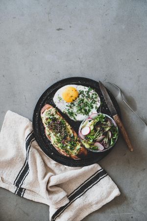 Avocado toast on sourdough bread with herbs and sprouts, with cloth napkin copy space