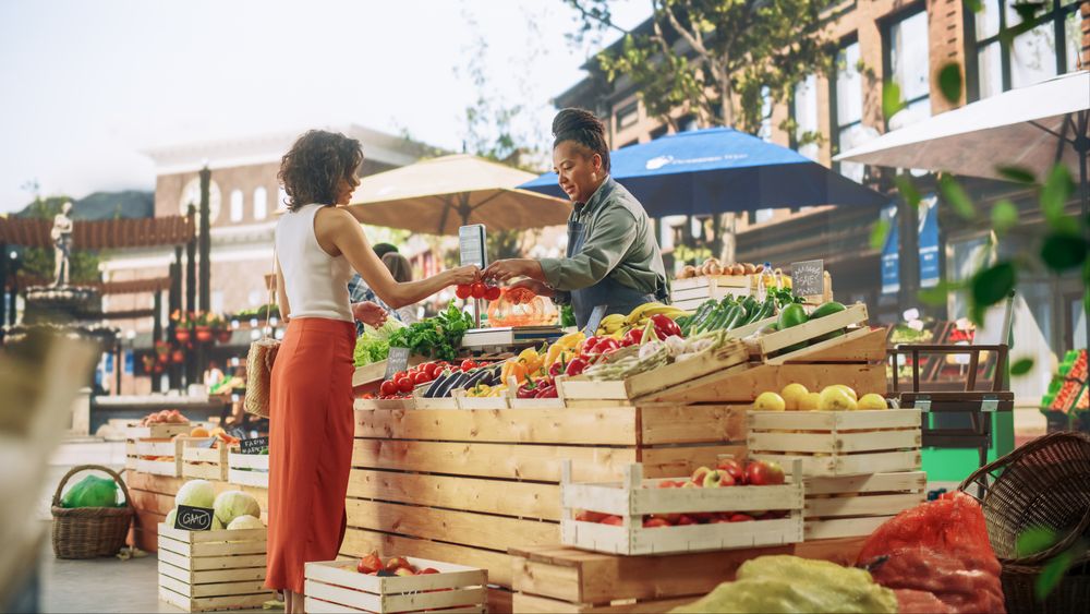 Young Customer Shopping for Fresh Organic Vegetables for a Fresh Salad with Tomatoes and Cucumbers.