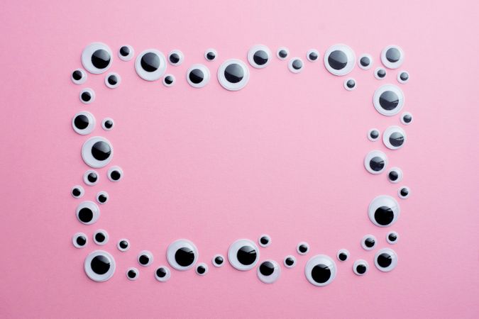Googly eyes on pink background in rectangle shape