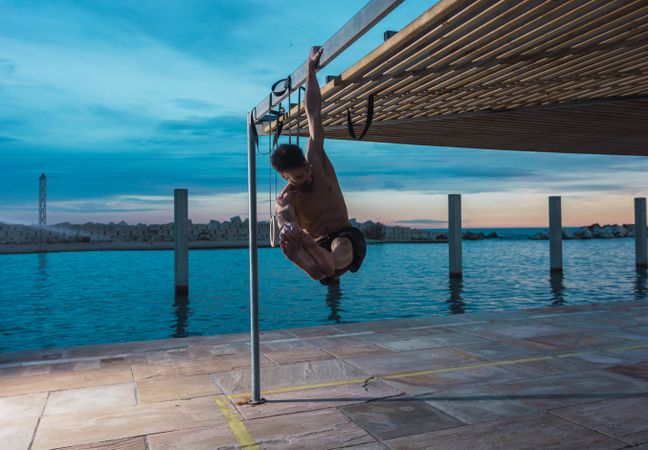 Athletic man balancing on gymnastic rings