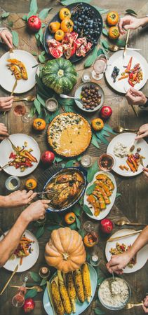 Flat-lay of friends feasting fall foods at Thanksgiving Day table