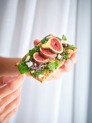 Crop person with delicious fruit slices on bread