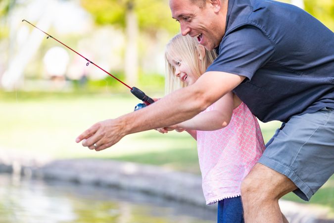 Young Father and Daughter Having Fun Fishing At The Lake