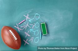 American football with play strategy on green chalkboard 0vBNo0