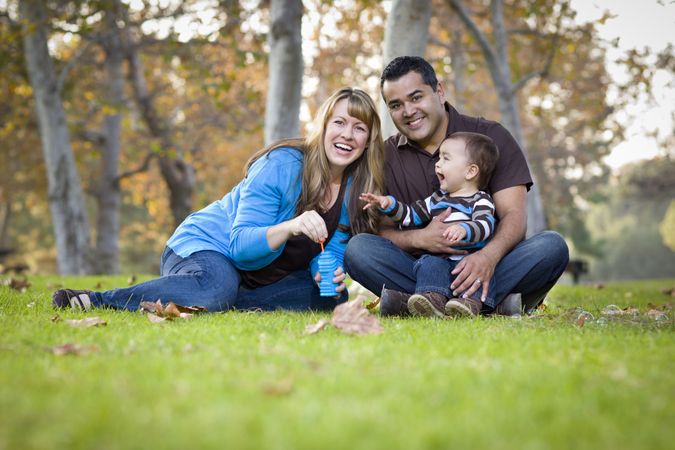 Young Family Playing with Bubbles In The Park