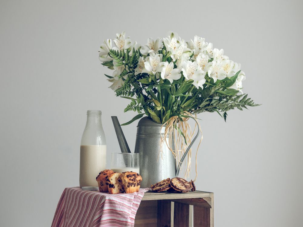 Rustic composition of flowers with milk and pastry