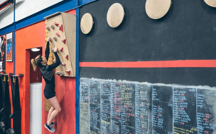 Woman hanging on the climbing wall