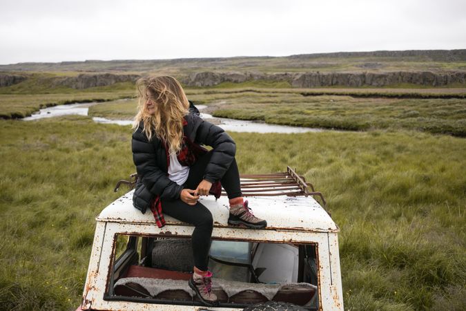 Female sitting on abandon vehicle