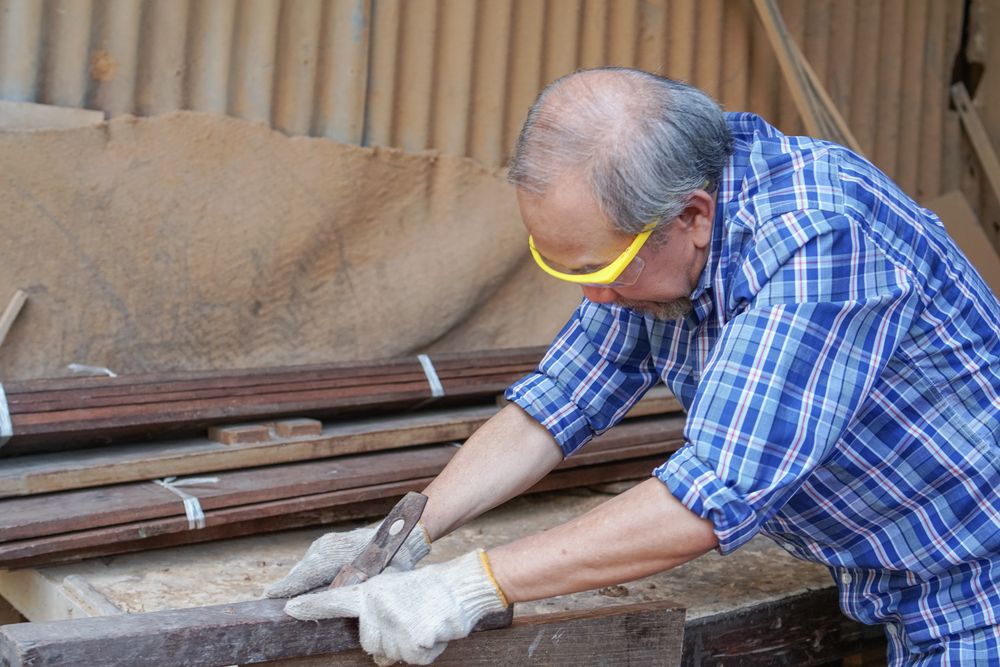 Asian male carpenter working on a wooden panel in the shop