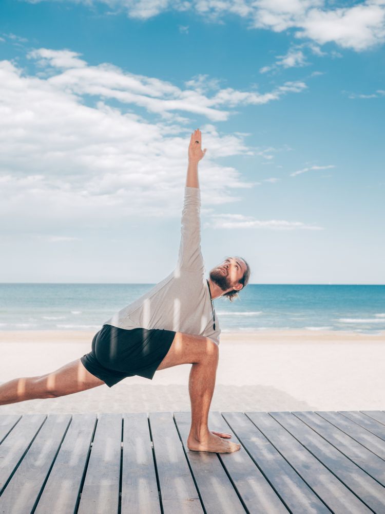Man doing yoga by the beach