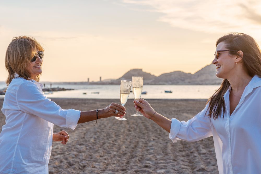 Happy family drinking wine on beach