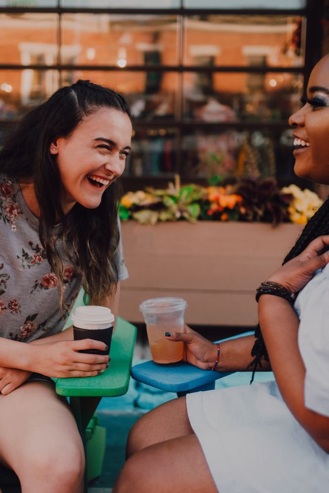 Multiethnic modern women talking at coffee shop
