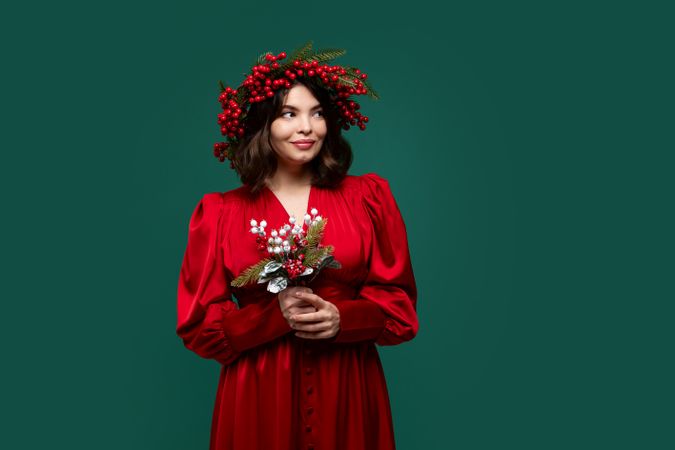 Portrait of woman in red dress with berry wreath