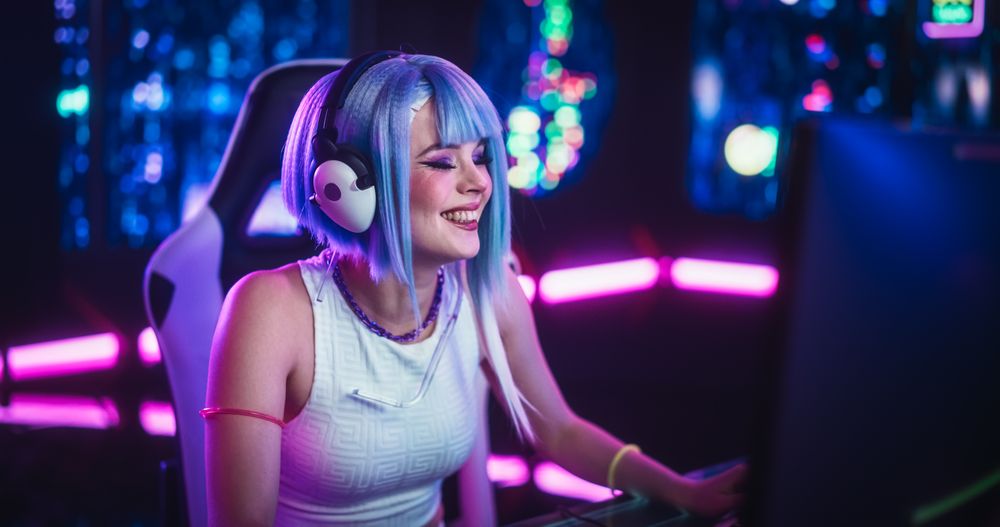 Portrait of a Stylish Streamer and Video Gamer with Blue Hair Chats with Internet Fans on Computer in Futuristic Cyber Technology Room.