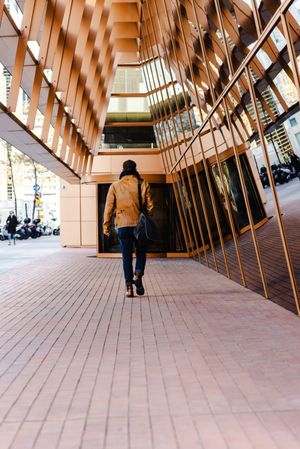 Stylish guy walking outside modern building