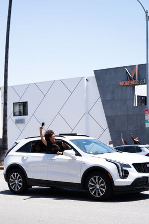 Los Angeles, CA, USA — June 14th, 2020: car driving on LA city street with woman protestor