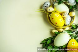 Easter card concept with yellow decorative Easter eggs in bowls on pastel background 0v3Ryo