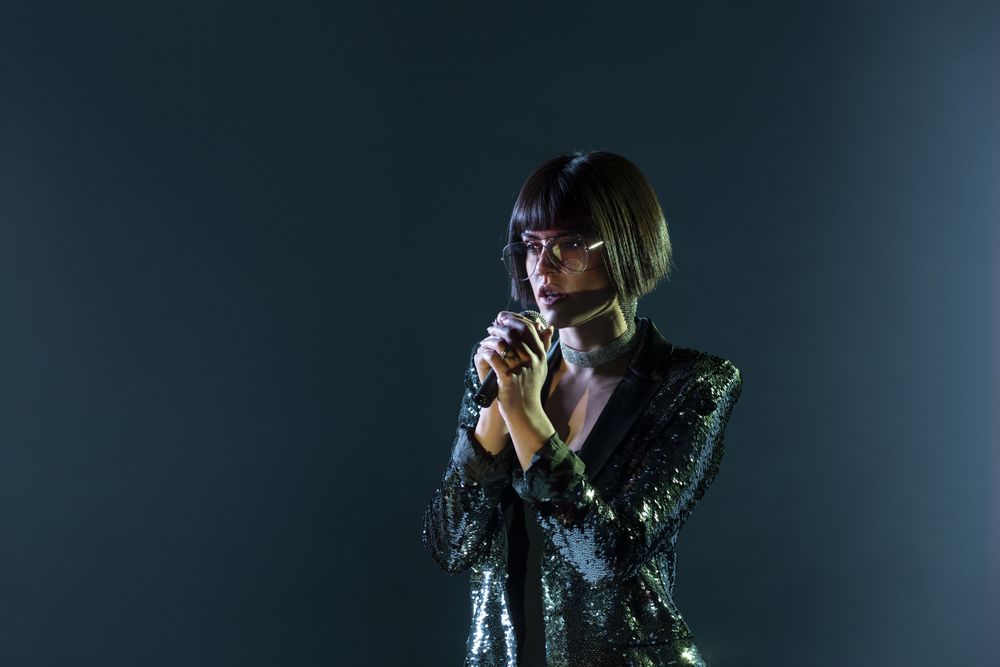 Stylish woman singing on stage