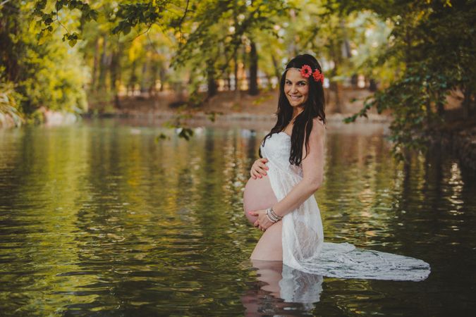 Pregnant woman standing in lake water