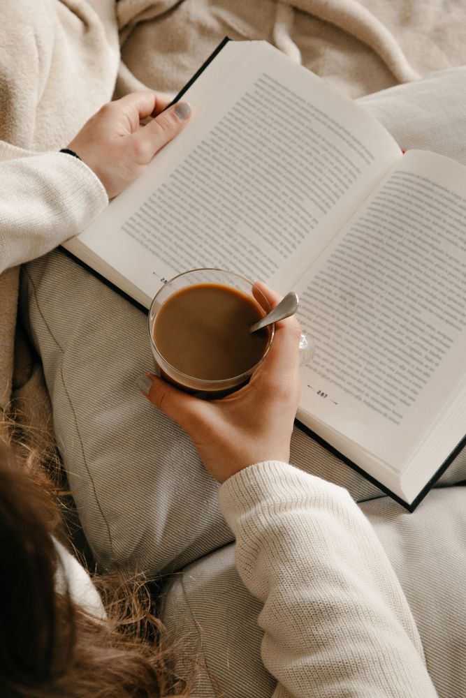 Person reading a book on the bed
