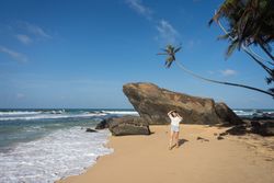 Woman in beachwear walking on sand barefoot