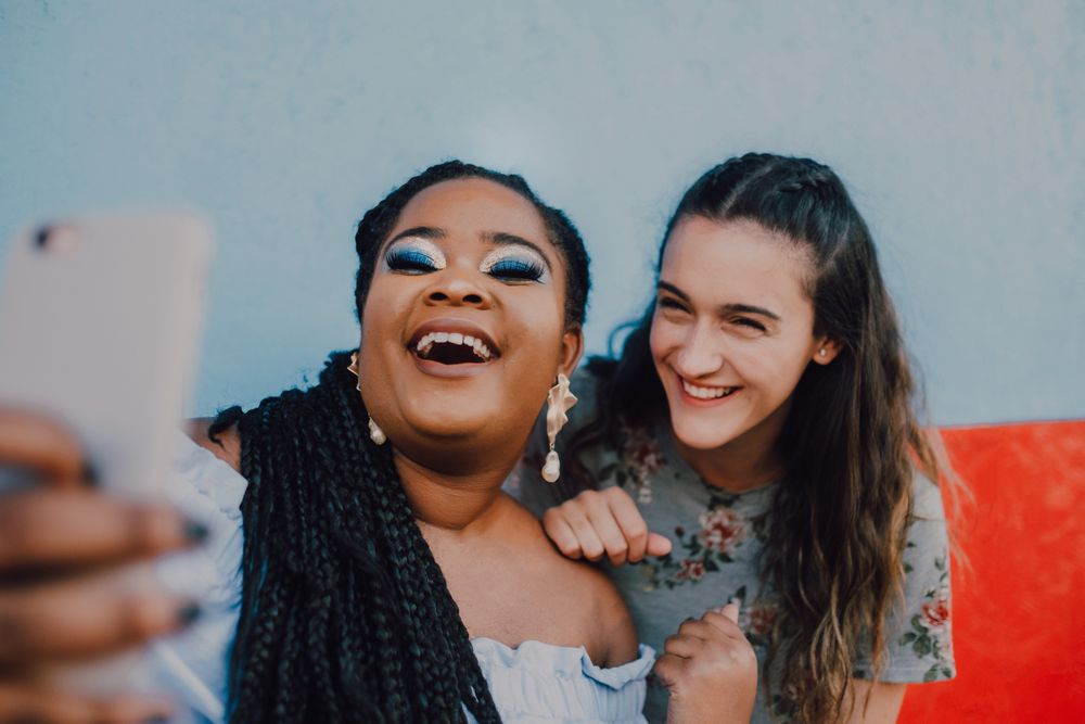 Smiling multiethnic women taking selfie