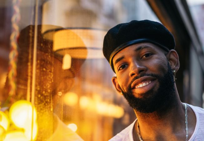 Black man near a glass. reflection and warm light