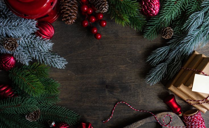 Top view of Christmas setting with pine branches and gifts on wooden table