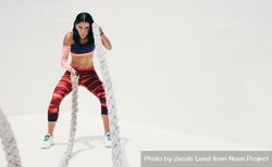 Athletic woman working out with battle ropes 5rqwp0