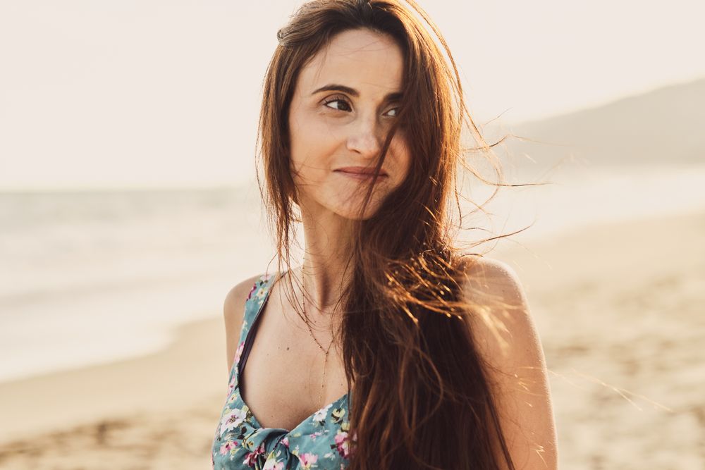 Young woman in the beach at sunset