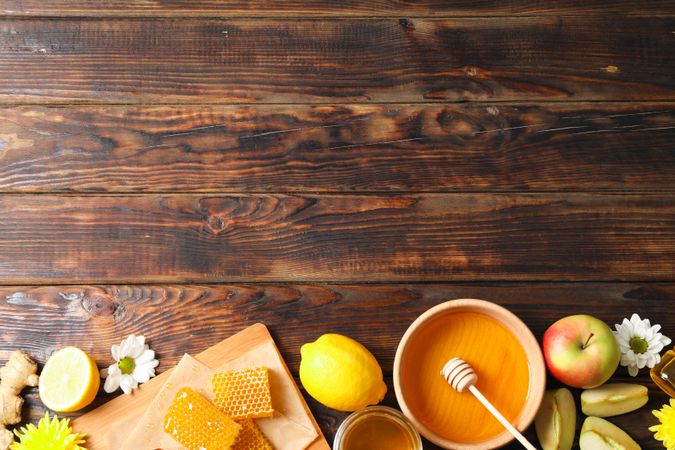 Flat lay with honey, flowers and fruits on wooden background, space for text