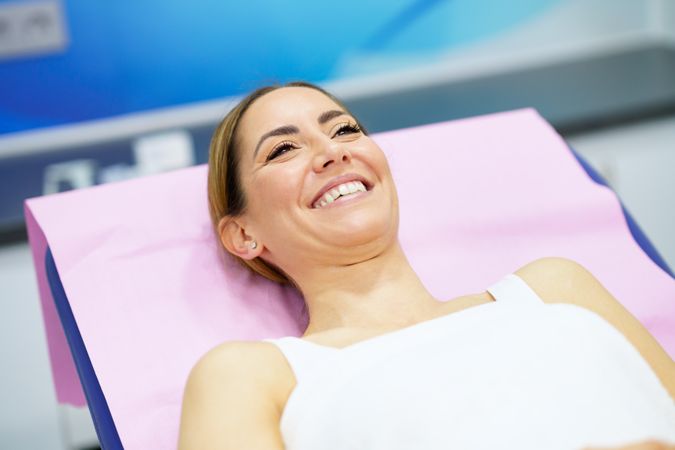 Woman smiling lying back in medical spa