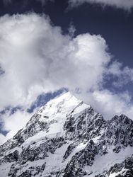 Beautiful view of snow capped mountain summit with clouds above