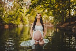 Pregnant woman standing in lake water
