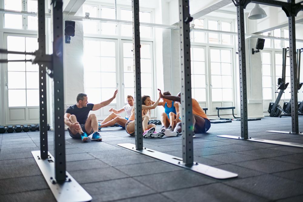 Group of people sitting and congratulating themselves after a workout