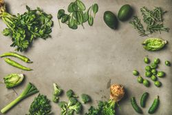 Arrangement of fresh green garden vegetables on concrete surface, copy space