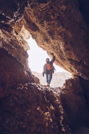 Relaxed tourist woman entering mountain cave